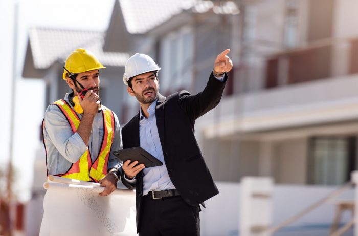Civil engineer and construction architecture worker are working in construction site with tablet and blueprints for planing about new construction site.Cooperation teamwork concept.